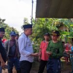 Foto : Endro Dwi Cahyono saat mengobrol dengan salah satu kepala desa dalam agenda penyaluran bansos kepada desa terdampak banjir (Sumber : Mitrapost.com/Anang SY)