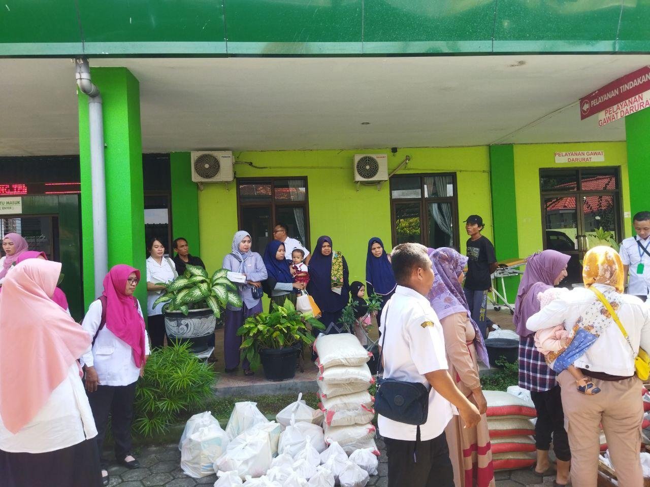Foto : Orang tua bersama anaknya mengambil Bantuan Pangan di Halaman Puskesmas Tambakromo, Dalam rangka pengentasan Stunting. (Sumber. Mitrapost.com/Ilham)