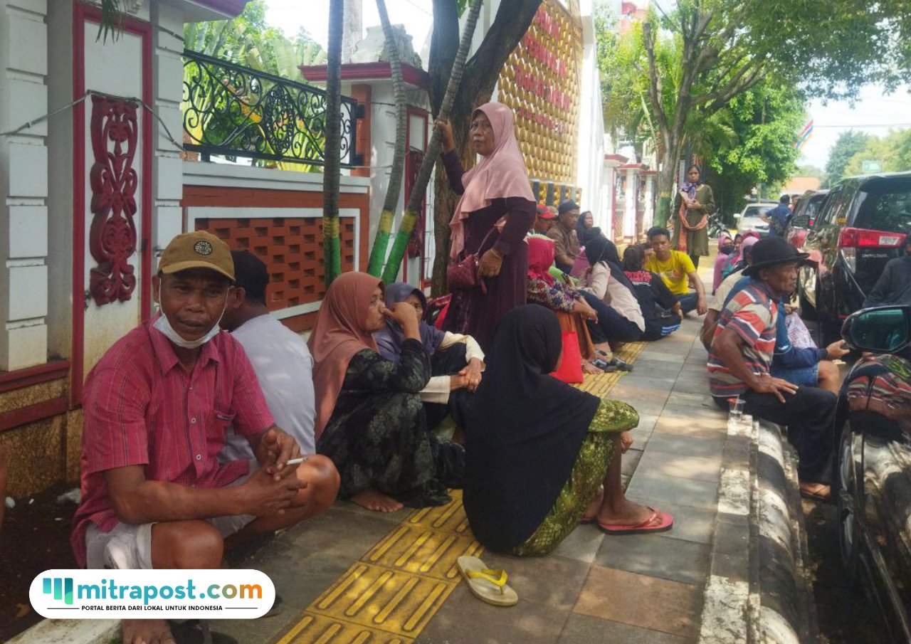 Foto : Petani Pundenrejo Kecamatan Tayu Kabupaten Pati tengah duduk di trotoar gedung DPRD Kabupaten Pati, Selasa (27/05/2025). (Sumber. Mitrapost.com/ Ilham)