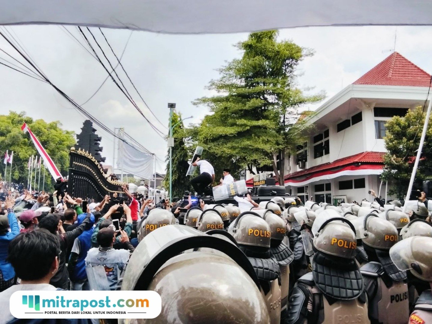 Foto : Bupati Pati Sudewo dilempari air mineral di halaman kantor Bupati dengan pengawalan ketat oleh kepolisian, Rabu (13/08/2025). (Sumber. Mitrapoat.com/ Ilham)