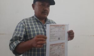 Foto: Mustofa, warga Desa Kertomulyo, Kecamatan Margoyoso memperlihatkan Surat Pemberitahuan Pajak Terutang (SPPT) (Mitrapost.com/ Kafi)