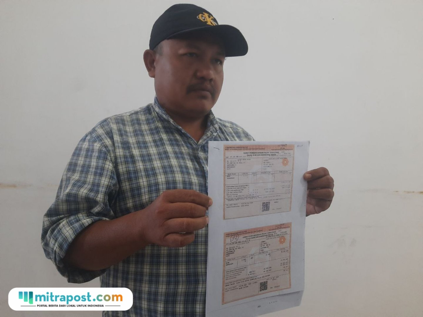 Foto: Mustofa, warga Desa Kertomulyo, Kecamatan Margoyoso memperlihatkan Surat Pemberitahuan Pajak Terutang (SPPT) (Mitrapost.com/ Kafi)