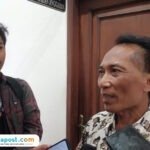 Foto: Perangkat Desa Jembulwunut, Kecamatan Gunungwungkal, Kabupaten Pati, Suyadi alias Cuk saat diwawancara oleh awak media (Mitrapost.com/ Kafi)
