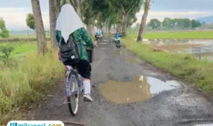 Foto: pelajar saat berangkat sekolah harus melalui jalan yang rusak parah (Mitrapost.com/ Kafi)
