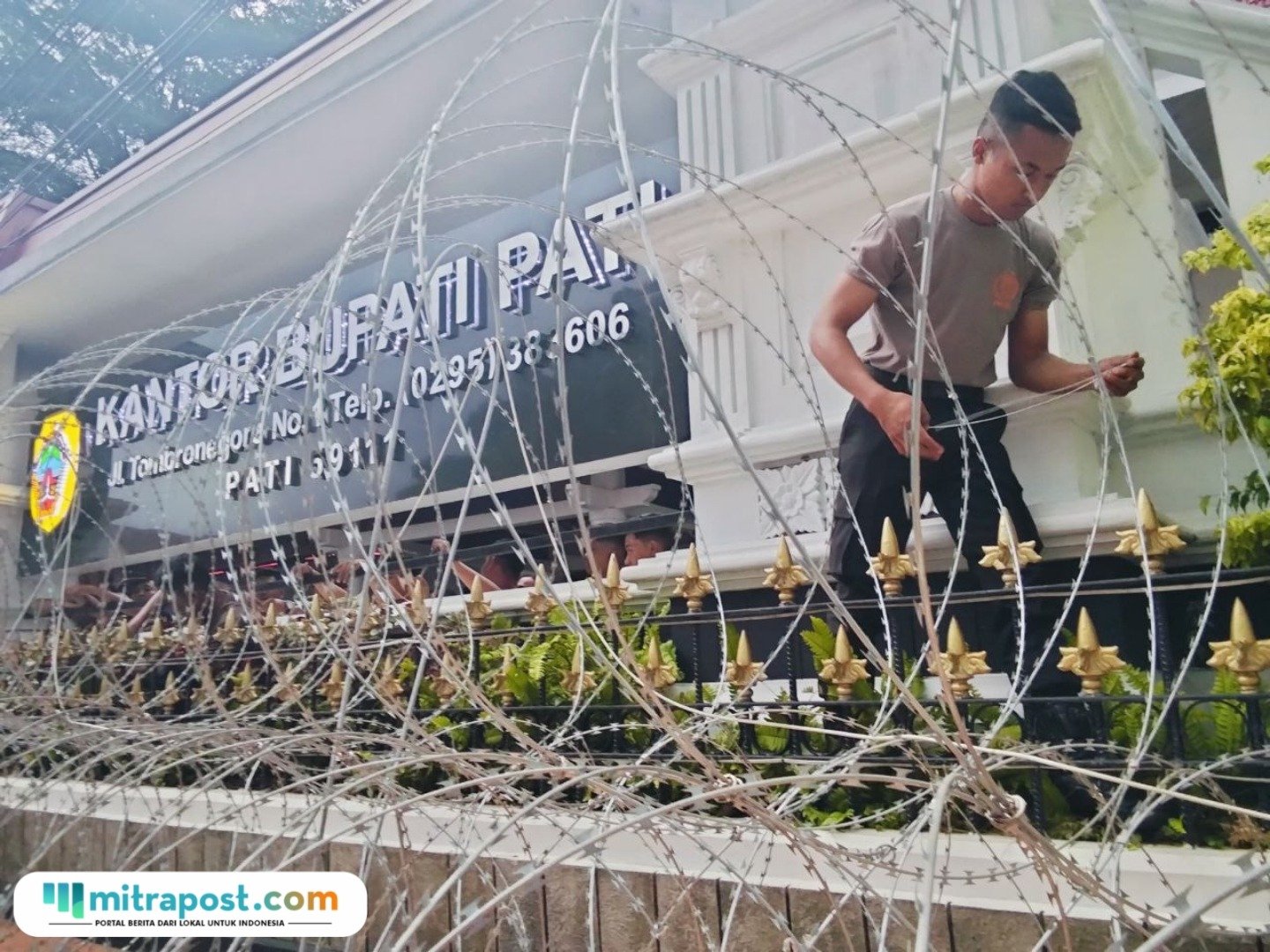 Picsart_25-10-31_09-27-35-691 Foto : Sejumlah personel kepolisian tengah melakukan pemasaran kawat berduri di depan Kantor Bupati Pati, Kamis (30/10/2025) sore. (Sumber. Mitrapost.com/ Ilham)