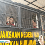 Foto : Supriyono alias Botok melambaikan tangan di dalam truk tahanan Kejaksaan Negeri Pati, Rabu (24/12/2025). (Sumber. Mitrapost.com/ Ilham)