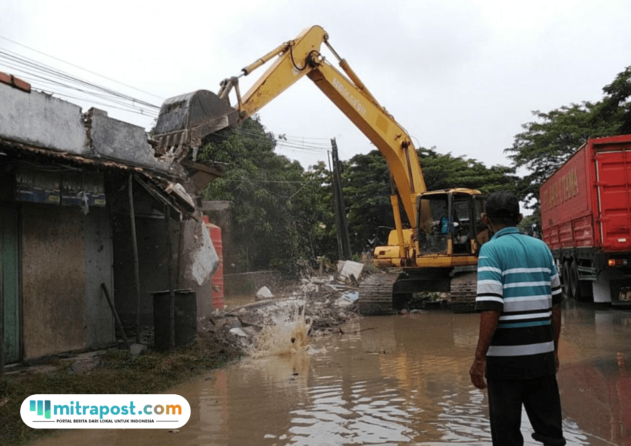 Foto : Alat berat tengah melakukan pembongkaran jembatan dan tiga kios di pinggir Sungai Widodaren, Kecamatan Batangan, Kamis (11/12/2025). (Sumber. Mitrapost.com/ Ilham) Banjir