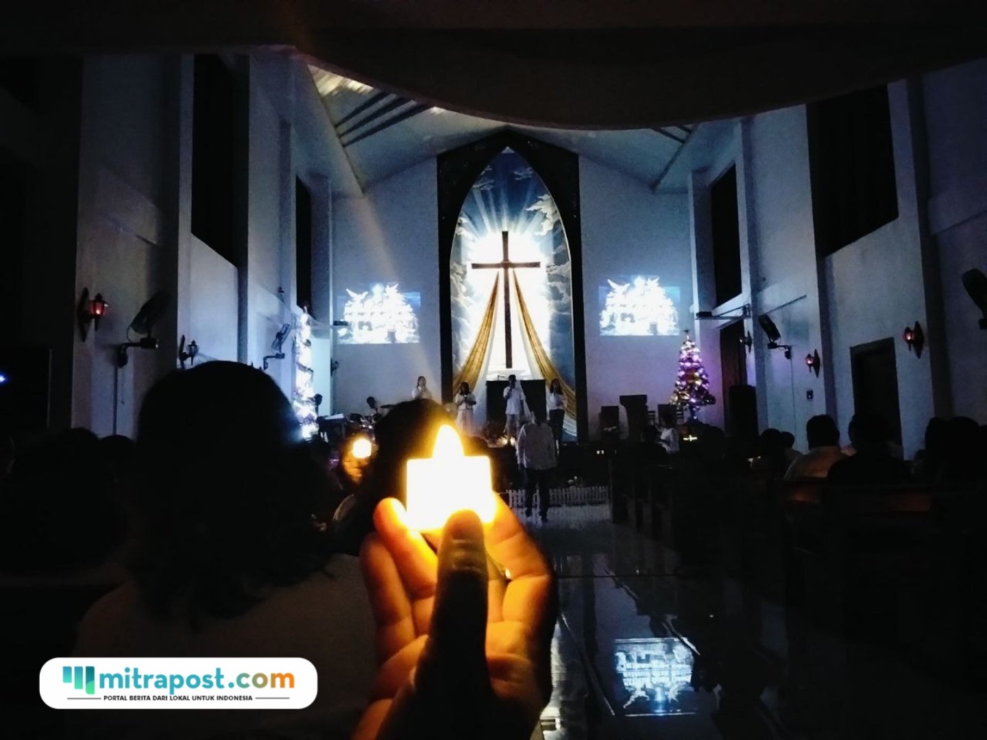 Foto : Jemaat GITJ Margorejo Pati di Desa Badegan menyalakan lilin. (Sumber. Mitrapost.com/ Ilham)
