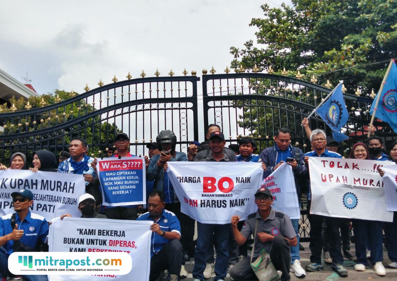 Foto : Buruh di Kabupaten Pati mendatangi kantor Bupati Pati dengan membawa sejumlah spanduk, Senin (22/12/2025). (Sumber. Mitrapost.com/ Ilham) Upah Minimum Kabupaten