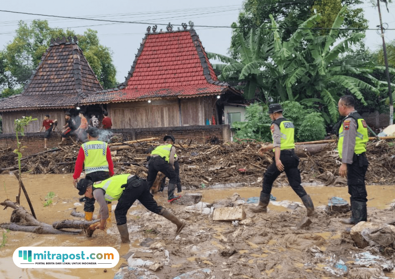Foto : Polisi tengah membersihkan lumpur di rumah warga Desa Bulumanis Kidul, Kecamatan Margoyoso Pati. (Sumber. Mitrapost.com/ Ilham)