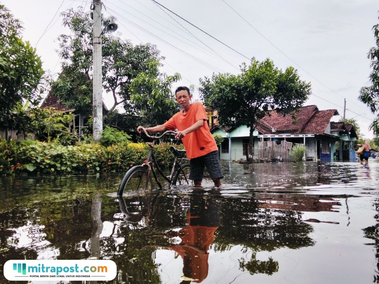 Foto : Aktivitas warga Desa Sidoarum Kecamatan Jakenan melintasi akses jalan yang tergenang banjir. (Sumber. Mitrapost.com/ Ilham)