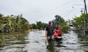 Foto : Parsono bersama dengan istri dan anaknya habis membeli kebutuhan dapur mengganggu ban karet. (Sumber. Mitrapost.com/ Ilham)