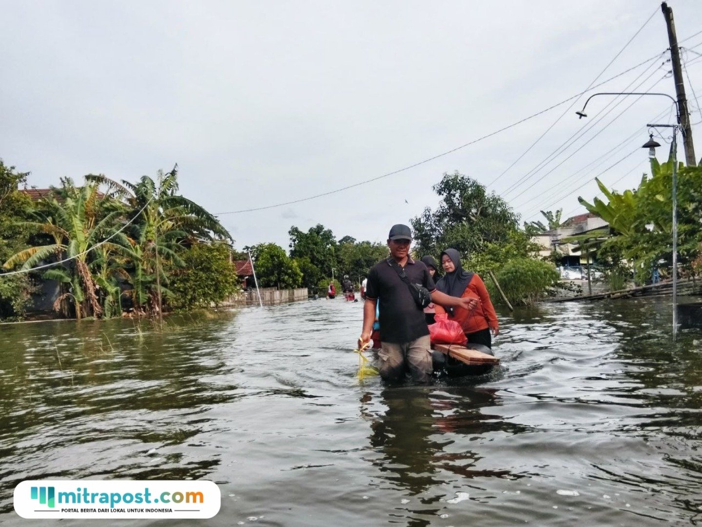 Foto : Parsono bersama dengan istri dan anaknya habis membeli kebutuhan dapur mengganggu ban karet. (Sumber. Mitrapost.com/ Ilham)