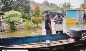 Foto : Hendi bersama istrinya menepikan perahu yang dinaiki. (Sumber. Mitrapost.com/ Ilham