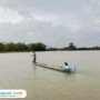 Foto : Rukin seorang petani Desa Banjarsari, Kecamatan Gabus menaikan perahu melintasi lahan sawahnya. (Sumber. Mitrapost.com/ Ilham)