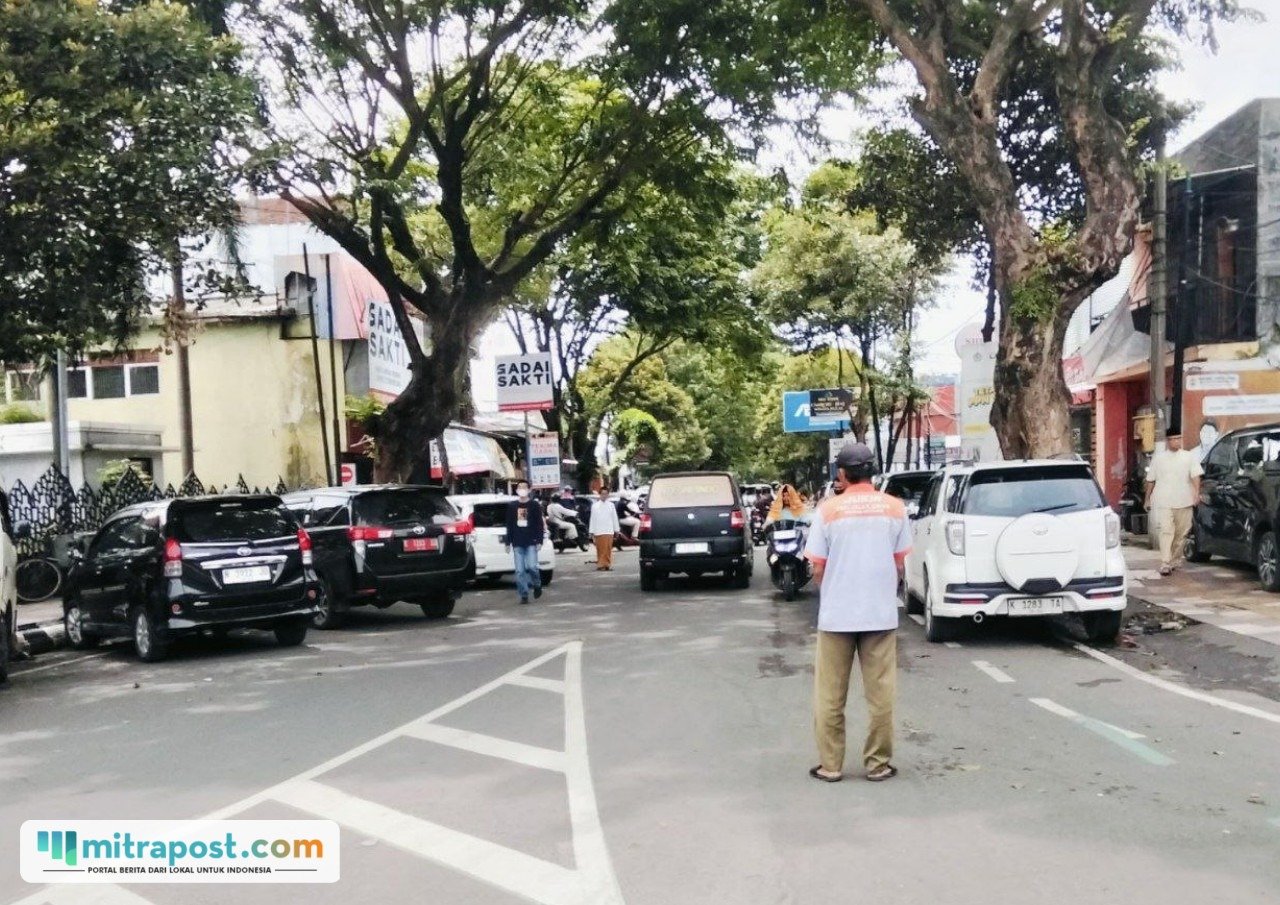Foto : Juru parkir di Jalan Panglima Sudirman tengah mengatur kendaraan. (Sumber. Mitrapost.com/ Ilham)