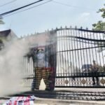 Foto : Asap membumbung ketika banner bergambar Kapolresta Pati berhasil dipadamkan oleh petugas di pintu gerbang Kantor Bupati Pati, Jumat (29/05/2026). (Sumber. Mitrapost.com/ Ilham) Foto : Asap membumbung ketika banner bergambar Kapolresta Pati berhasil dipadamkan oleh petugas di pintu gerbang Kantor Bupati Pati, Jumat (29/05/2026). (Sumber. Mitrapost.com/ Ilham) Pembakaran Banner