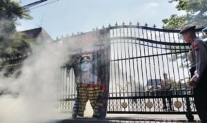Foto : Asap membumbung ketika banner bergambar Kapolresta Pati berhasil dipadamkan oleh petugas di pintu gerbang Kantor Bupati Pati, Jumat (29/05/2026). (Sumber. Mitrapost.com/ Ilham) Pembakaran Banner