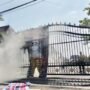 Foto : Asap membumbung ketika banner bergambar Kapolresta Pati berhasil dipadamkan oleh petugas di pintu gerbang Kantor Bupati Pati, Jumat (29/05/2026). (Sumber. Mitrapost.com/ Ilham) Pembakaran Banner