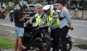 Ilustrasi polisi tilang pengendara Ditlantas Polda Metro Jaya Akan Kembali Lakukan Tilang Manual, Fokus pada Pelanggaran Pelat Nomor