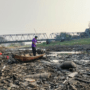 Foto : Nelayan sungai naik perahu saat sungai mengering. (Sumber. Mitrapost.com/ Ilham)
