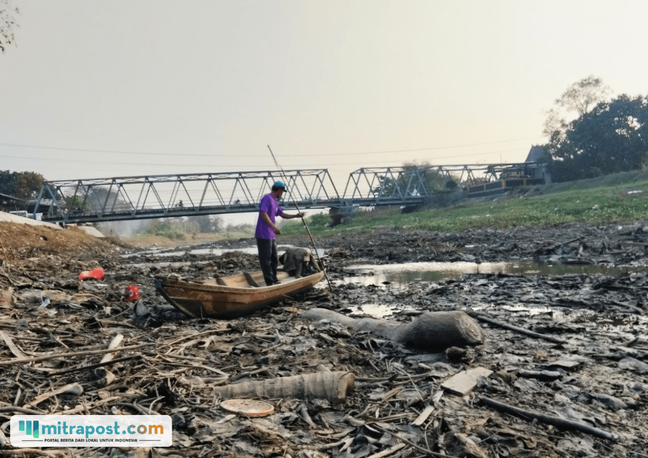 Foto : Nelayan sungai naik perahu saat sungai mengering. (Sumber. Mitrapost.com/ Ilham)