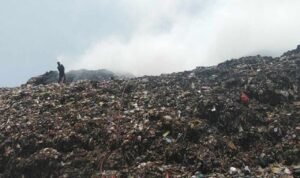 Foto : Terlihat dari kejauhan dua petugas pemadam kebakaran berjibaku memadamkan api di TPS Plosojenar Pati. (Sumber. Mitrapost.com/ Ilham)