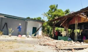 Foto : Pagar di depan rumah berhimpitan dengan Punden dibongkar. (Sumber. Mitrapost.com/ Ilham)