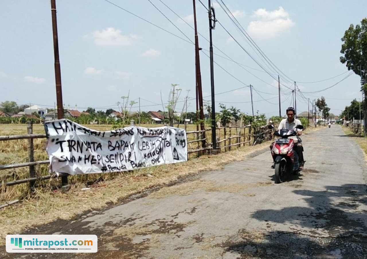Foto : Jalan di Bumirejo Kecamatan Margorejo dipasangi spanduk bernada kritik. (Sumber. Mitrapost.com/ Ilham)