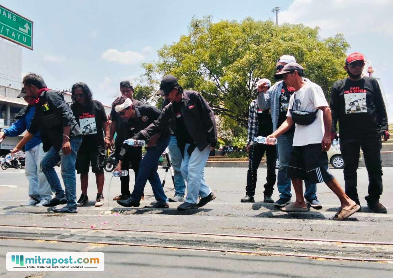 Foto : Aksi gabut bunga dan siram air doa di depan pintu gerbang Bupati Pati. (Sumber. Mitrapost.com/ Ilham)