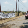 Foto : Jalan Rusak Dipasangi Spanduk di Desa Bumirejo Kecamatan Margorejo. (Sumber. Mitrapoat.com/ Ilham)